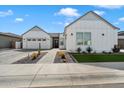 Charming exterior of a white single-story home with a two-car garage, desert landscaping, and paved walkway at 4097 E Tonto Pl, Chandler, AZ 85249