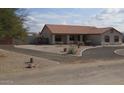 A spacious home with a circular driveway and a large yard with native landscaping at 4511 S 181St Ave, Goodyear, AZ 85338