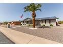 Inviting home with desert landscape and mature palm tree, showcasing American flag and solar panels at 6456 E Dallas St, Mesa, AZ 85205