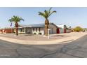 Charming single-story house with desert landscaping, enhanced by palm trees and solar panels at 6456 E Dallas St, Mesa, AZ 85205