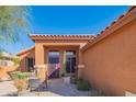 Welcoming home entrance with a stylish door, desert plants, and an inviting outdoor seating area at 7138 W Buckskin Trl, Peoria, AZ 85383