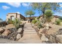 A desert home with a stone staircase leading to the front entrance at 7848 E Parkview Ln, Scottsdale, AZ 85255