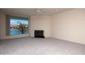 Bright living room with a fireplace and a large window overlooking the water at 10080 E Mountain View Lake Dr # 138, Scottsdale, AZ 85258