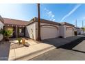 View of a home with an attached garage, a red tile roof, desert landscaping, and a mature palm tree at 1317 E Cobb Dr, Tempe, AZ 85288