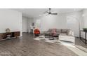 Bright, open living room with wood-look tile floors, modern furniture, and ample natural light at 17339 W Paraiso Ln, Surprise, AZ 85387