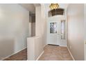 Welcoming foyer with tile flooring, high ceilings, and an ornate light fixture at 18123 W Hayden Dr, Surprise, AZ 85374