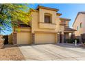Two-story tan stucco home with a three-car garage and mature landscaping at 19221 N Toya St, Maricopa, AZ 85138