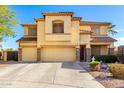 Two-story tan stucco home with a three-car garage and mature landscaping at 19221 N Toya St, Maricopa, AZ 85138