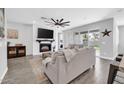 Comfortable living room with a large tv, fireplace, and a ceiling fan at 20159 E Rosa Rd, Queen Creek, AZ 85142