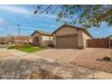 A beautiful property showcasing a well-kept yard and a brick-paved driveway leading to a tan-colored house at 20325 E Hummingbird Dr, Queen Creek, AZ 85142