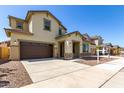 Inviting two-story home boasting a spacious driveway and a neatly landscaped front yard with young trees at 20951 E Via Del Sol St, Queen Creek, AZ 85142