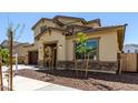 Charming two-story home featuring a well-manicured front yard and elegant exterior stone accents at 20951 E Via Del Sol St, Queen Creek, AZ 85142