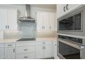 Close-up of kitchen appliances, including a KitchenAid microwave and oven, plus sleek white cabinetry at 2121 W Sonoran Desert Dr # 13, Phoenix, AZ 85085