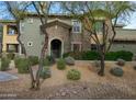 Two-story home with stone and stucco accents, mature trees, and desert landscaping at 21320 N 56Th St # 1085, Phoenix, AZ 85054