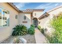 The front entrance of this home features desert landscaping with a tile walkway leading to an ornate front door at 22722 N 120Th Ln, Sun City, AZ 85373