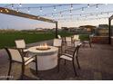 Cozy outdoor fire pit area with chairs, perfect for gatherings, with string lights and neighborhood in the background at 3294 W Storm Cloud St, San Tan Valley, AZ 85144