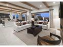 Open-concept living room featuring neutral tones, wood beam ceilings, and access to the backyard at 3307 W Storm Cloud St, San Tan Valley, AZ 85144