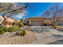 Beautiful desert home featuring mature trees, cacti, stone landscaping and a large driveway at 34435 N 68Th Way, Scottsdale, AZ 85262