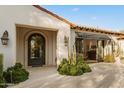 Charming facade with a decorative iron door, complemented by lush desert landscaping and stone accents at 6640 E Kasba Cir, Paradise Valley, AZ 85253