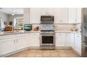 Modern kitchen featuring stainless steel oven, microwave, gas range, and hood, plus white cabinets and tile backsplash at 7370 E Sunset Sky Cir, Scottsdale, AZ 85266
