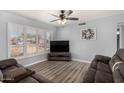 Cozy living room with new flooring, a ceiling fan, and bright natural light from large windows at 951 W La Jolla Dr, Tempe, AZ 85282
