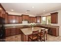 Spacious kitchen featuring granite countertops, stainless steel appliances, and a large center island at 9901 E Bahia Dr, Scottsdale, AZ 85260