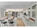 Bright kitchen with white cabinets, modern appliances, and a breakfast bar seating area at 10609 W Concho Cir, Sun City, AZ 85373