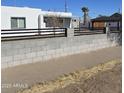 The home has a xeriscaped front yard and a gray block perimeter wall with a black fence on top at 1414 E Moreland St, Phoenix, AZ 85006