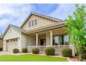 Attractive home with a cozy front porch, offering a welcoming entrance and curb appeal at 14360 W Windrose Dr, Surprise, AZ 85379