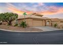 Corner-lot house with two-car garage and desert landscaping against a vibrant sunset backdrop at 14728 W Cheery Lynn Dr, Goodyear, AZ 85395