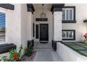 Inviting front entrance with a black front door, modern lighting, and manicured landscaping at 14820 N 44Th Pl, Phoenix, AZ 85032