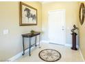 Elegant entryway with tiled floor design, decorative table, artwork, and view of the front door at 16416 W Rock Springs Ln, Surprise, AZ 85374