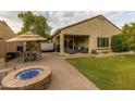 Back patio with comfortable outdoor furniture, BBQ grill, and desert landscaping at 17507 W Fetlock Trl, Surprise, AZ 85387