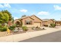 Charming single-story home with mature landscaping and a decorative entry gate at 17553 N Thornberry Dr, Surprise, AZ 85374