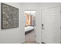 View of a staged bedroom with white door, textured peach walls, and modern chandelier at 17819 W Mission Ln, Waddell, AZ 85355