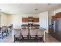 Modern kitchen featuring a large island with seating, stainless steel appliances, and wood-look flooring at 23689 W Watkins St, Buckeye, AZ 85326