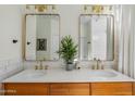 Bathroom featuring a double sink vanity with gold fixtures, white countertops, and a tile backsplash at 2626 E Valencia St, Gilbert, AZ 85296