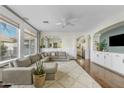 Bright living room with a plush sectional sofa, a ceiling fan, and large windows with designer curtains at 2626 E Valencia St, Gilbert, AZ 85296