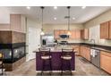 Modern kitchen with granite countertops, stainless steel appliances, and a center island with seating at 2798 W William Ln, San Tan Valley, AZ 85144