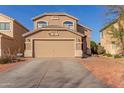 Two-story home featuring a tan exterior, desert landscaping, large driveway, and attached two-car garage at 28549 N Dolomite Ln, San Tan Valley, AZ 85143