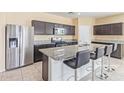 Modern kitchen featuring stainless steel appliances, granite countertops, and an island with bar seating at 3206 N 310Th Ln, Buckeye, AZ 85396