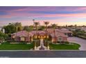 A picturesque single-story house with a tile roof, a water feature, and lush landscaping viewed at twilight at 3937 E Norcroft Cir, Mesa, AZ 85215