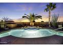 Beautiful pool with a fountain feature and lush landscaping, perfect for outdoor relaxation and entertaining at 40830 W Bedford Dr, Maricopa, AZ 85138