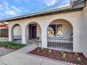 Cozy front porch with decorative arches, a black metal fence, and colorful landscaping at 4929 W Christy Dr, Glendale, AZ 85304