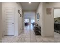 Long entryway with tile flooring, an open view of the living area, and a side view of the laundry room at 523 S 201St Ave, Buckeye, AZ 85326