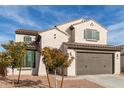 Inviting home exterior featuring a two-car garage, desert landscaping, and a light stucco facade at 523 S 201St Ave, Buckeye, AZ 85326