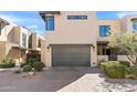 Contemporary exterior showcasing desert landscaping, large windows, a gray garage door, and stonework at 5541 E Stella Ln, Paradise Valley, AZ 85253