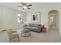 Bright living room featuring neutral tones, modern furnishings, ceiling fan, and natural light from a large window at 7726 E Baseline Rd # 110, Mesa, AZ 85209