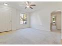 Bright living room features neutral carpet, ceiling fan, and arched doorway at 7726 E Baseline Rd # 110, Mesa, AZ 85209