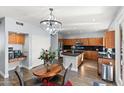 Spacious kitchen and dining area with modern appliances, a central island, and stylish light fixtures at 8421 W Alex Ave, Peoria, AZ 85382